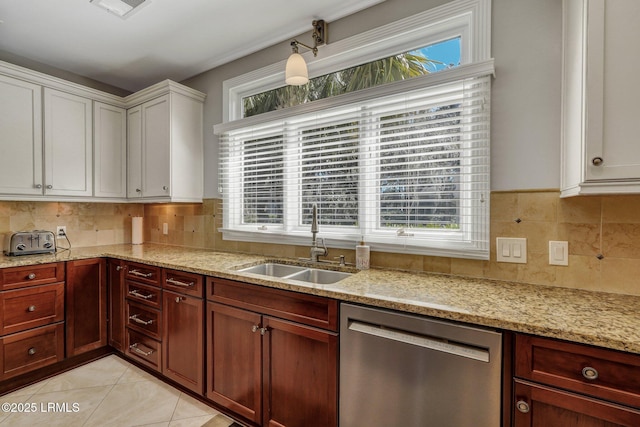 kitchen with white cabinets, light stone countertops, stainless steel dishwasher, a sink, and light tile patterned flooring