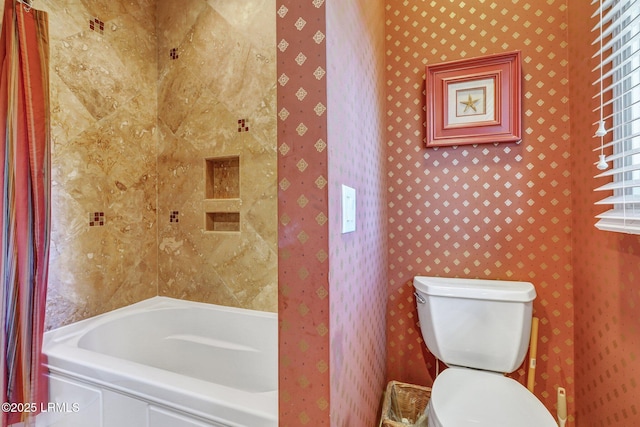 bathroom with a tub to relax in, toilet, and wallpapered walls