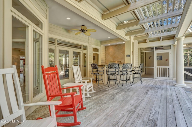 wooden terrace featuring outdoor dry bar, a ceiling fan, and french doors