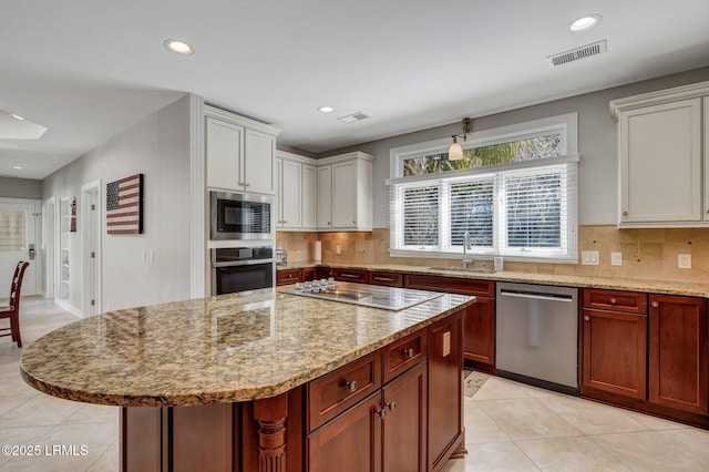 kitchen featuring tasteful backsplash, visible vents, stainless steel appliances, and a sink