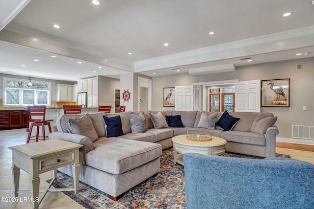 living room with recessed lighting, visible vents, and crown molding