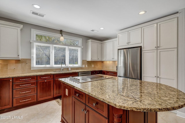 kitchen with visible vents, decorative backsplash, stainless steel appliances, a sink, and light tile patterned flooring