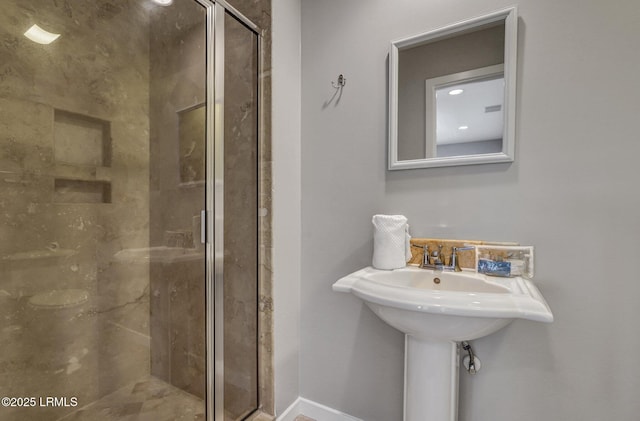 bathroom featuring a shower stall and baseboards