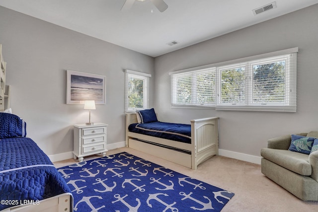 carpeted bedroom featuring ceiling fan, visible vents, and baseboards