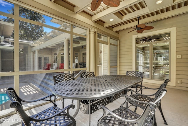 sunroom with ceiling fan, beamed ceiling, and plenty of natural light