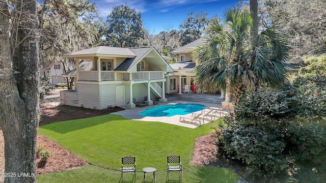 back of property featuring an outdoor pool, a yard, stairs, a wooden deck, and a patio area