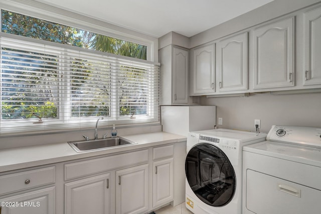 laundry area featuring cabinet space, a sink, and washing machine and clothes dryer