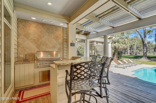 exterior space featuring area for grilling, a sink, grilling area, an outdoor pool, and a pergola