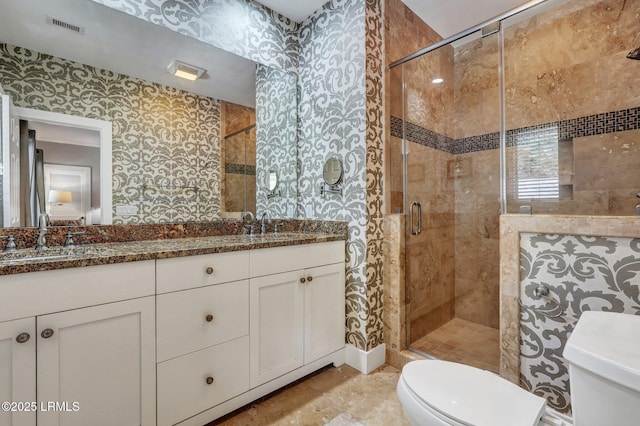 bathroom featuring toilet, a stall shower, visible vents, and a sink