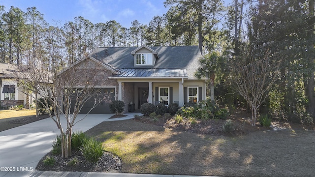 view of front of property featuring driveway, metal roof, an attached garage, a standing seam roof, and a porch