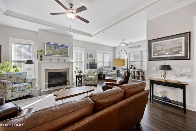 living room featuring ceiling fan, a tray ceiling, and dark hardwood / wood-style flooring