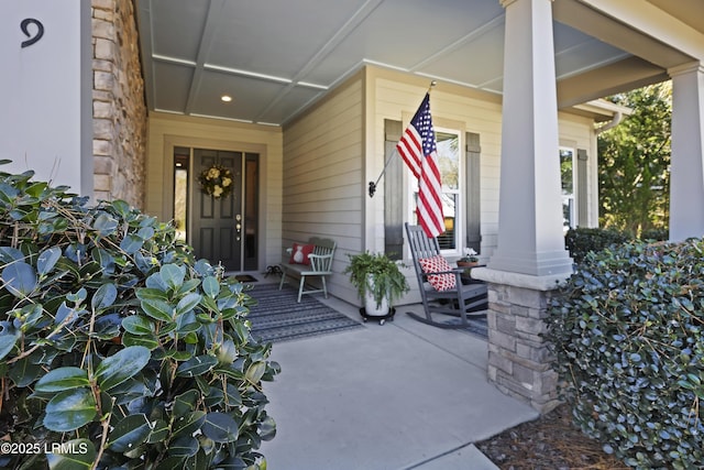 view of exterior entry featuring covered porch