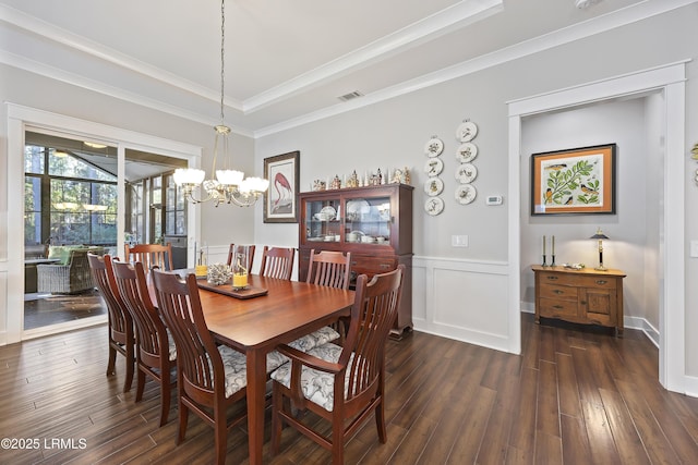 dining room featuring ornamental molding, dark hardwood / wood-style flooring, and a chandelier