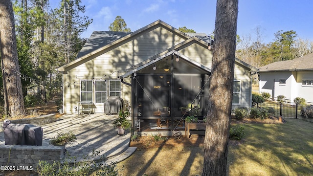 back of house with a yard, a sunroom, and a patio