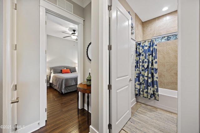 bathroom featuring ceiling fan, wood-type flooring, and shower / bath combo with shower curtain