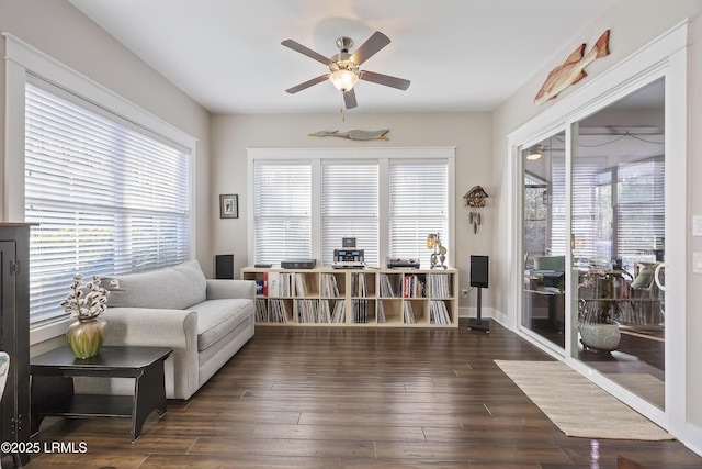 living area featuring dark hardwood / wood-style flooring and ceiling fan