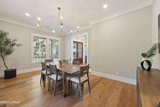 dining room with ornamental molding, light hardwood / wood-style floors, and french doors