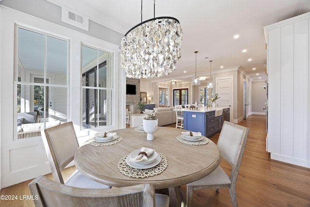 dining room with an inviting chandelier, a wealth of natural light, and wood-type flooring