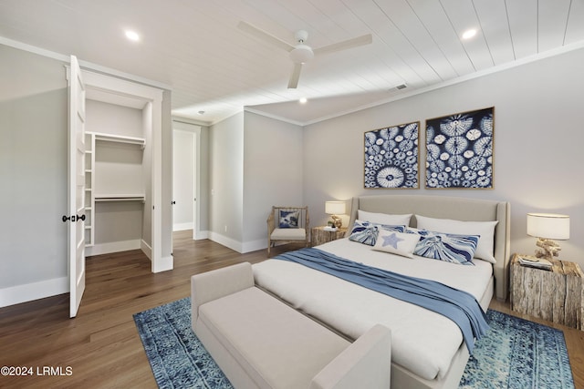 bedroom featuring hardwood / wood-style floors, ornamental molding, a spacious closet, ceiling fan, and a closet