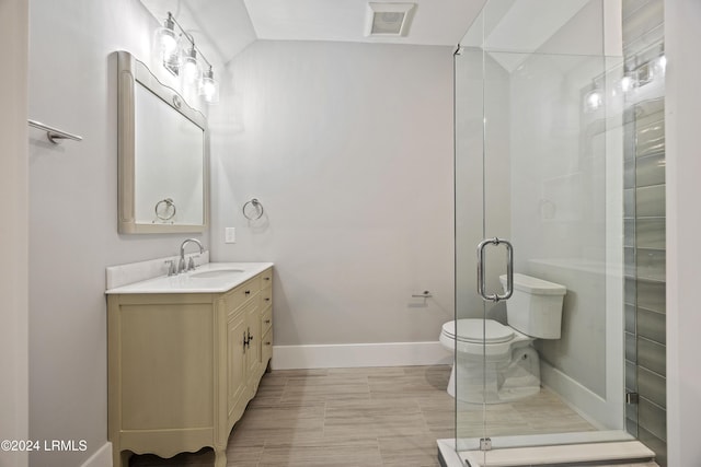 bathroom featuring vanity, a shower with door, and toilet