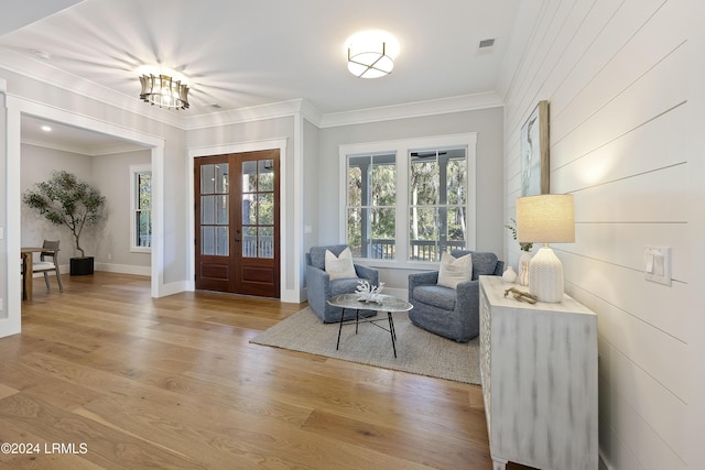 living area with hardwood / wood-style floors, crown molding, and french doors