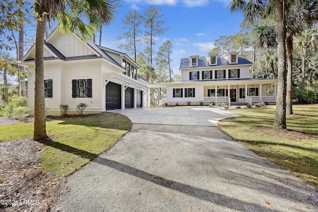 view of front of house with a garage, covered porch, and a front lawn