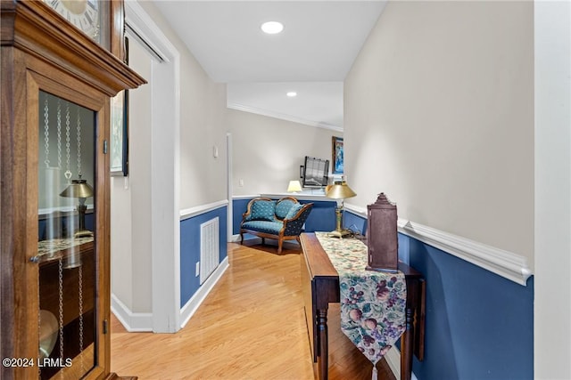 hallway featuring ornamental molding and light wood-type flooring