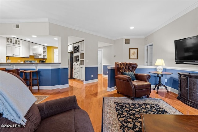 living room with ornamental molding and light hardwood / wood-style flooring