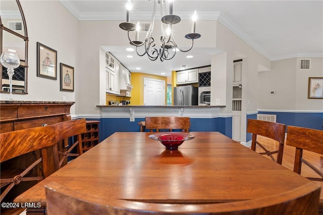 dining area featuring ornamental molding and a chandelier