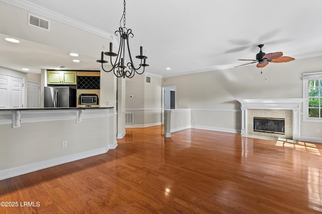 unfurnished living room featuring visible vents, ornamental molding, wood finished floors, recessed lighting, and a fireplace