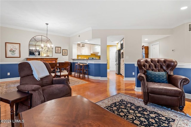 living room featuring ornamental molding, light hardwood / wood-style flooring, and a notable chandelier