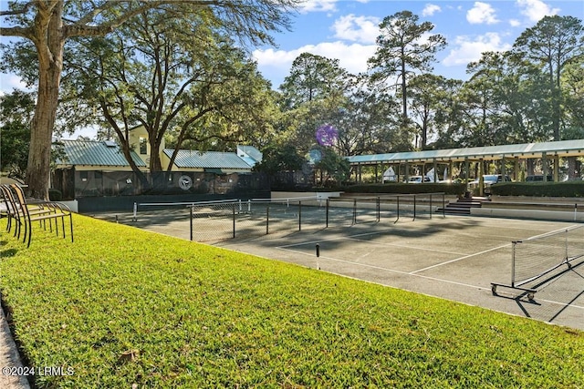 view of tennis court featuring a lawn