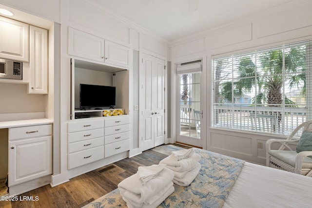 bedroom with dark wood-type flooring, access to outside, and ornamental molding