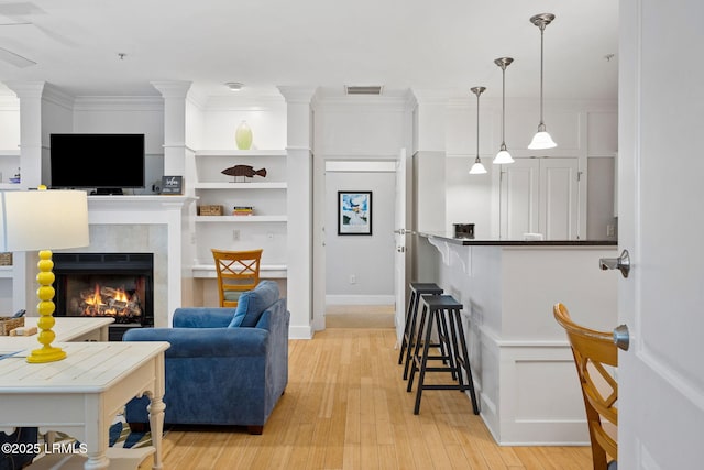 living room with ornamental molding and light wood-type flooring