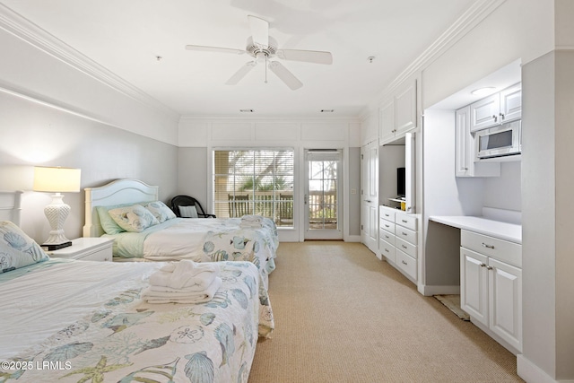 carpeted bedroom with access to exterior, crown molding, built in desk, and ceiling fan