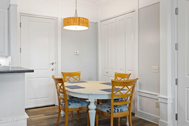 dining area with crown molding and dark hardwood / wood-style flooring