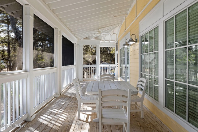 unfurnished sunroom with ceiling fan, plenty of natural light, and vaulted ceiling