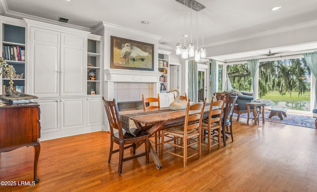 5 Petigru Dr, Beaufort, SC 29902 - dining room featuring ornamental molding, light wood-type flooring, a tile fireplace, and recessed lighting
