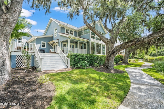 5 Petigru Dr, Beaufort, SC 29902 - view of front of home featuring stairway, a front lawn, stucco siding, and ceiling fan
