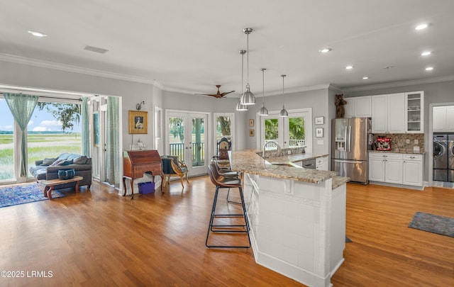 5 Petigru Dr, Beaufort, SC 29902 - kitchen featuring appliances with stainless steel finishes, french doors, light wood-style floors, white cabinetry, and recessed lighting
