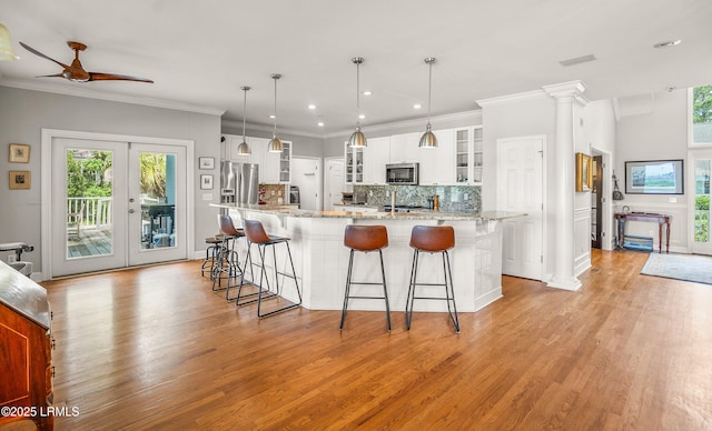 5 Petigru Dr, Beaufort, SC 29902 - kitchen featuring appliances with stainless steel finishes, ceiling fan, white cabinetry, tasteful backsplash, and light wood-style flooring