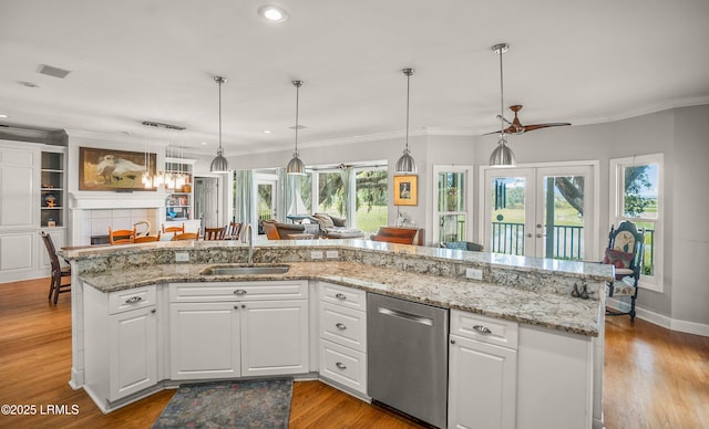 5 Petigru Dr, Beaufort, SC 29902 - kitchen featuring stainless steel dishwasher, french doors, white cabinetry, light wood-style flooring, and decorative light fixtures