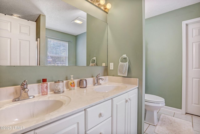 bathroom with double vanity, tile patterned flooring, a textured ceiling, and a sink