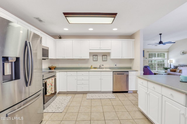 kitchen featuring light countertops, appliances with stainless steel finishes, a sink, and white cabinetry