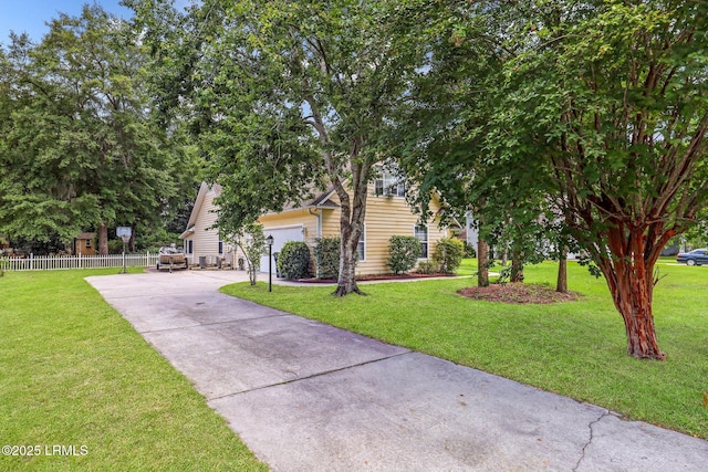 view of property hidden behind natural elements with a garage, a front yard, concrete driveway, and fence