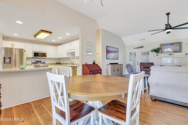 dining room featuring light wood-type flooring, ceiling fan, vaulted ceiling, and recessed lighting