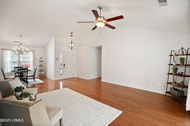 living room with wood-type flooring, lofted ceiling, and ceiling fan with notable chandelier