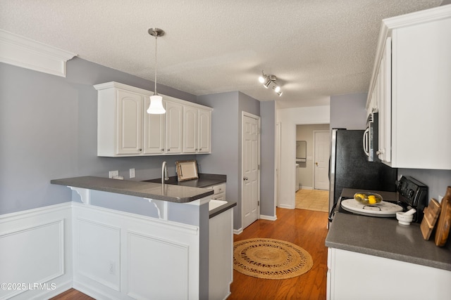 kitchen with pendant lighting, white cabinetry, a textured ceiling, kitchen peninsula, and electric stove