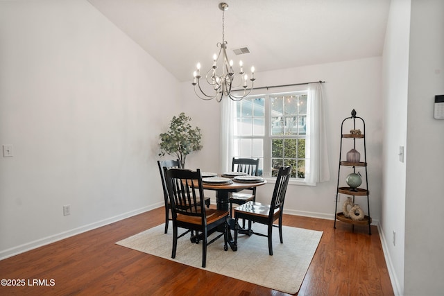 dining space featuring vaulted ceiling, a chandelier, and hardwood / wood-style floors