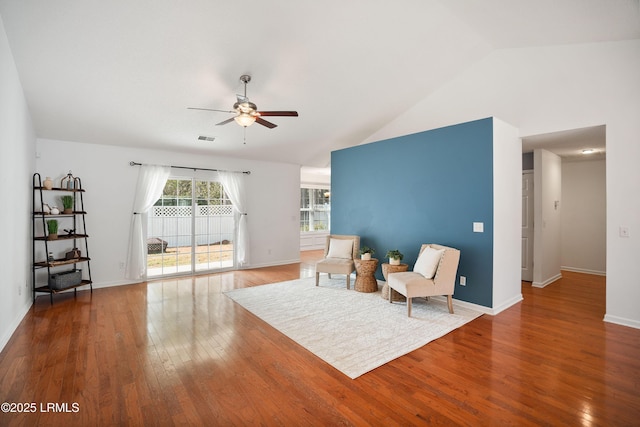 living area featuring hardwood / wood-style flooring, vaulted ceiling, and ceiling fan